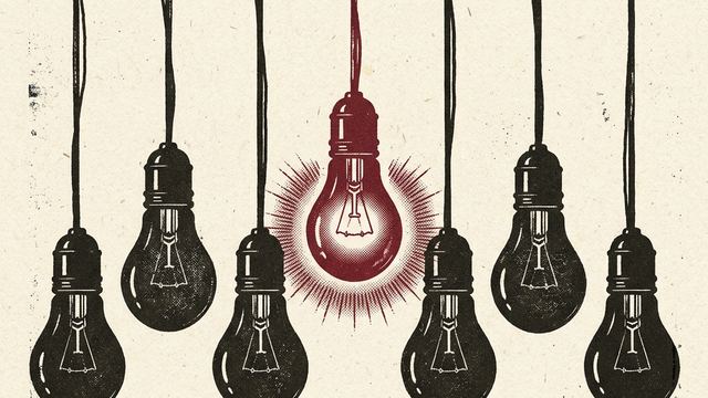 A single glowing lightbulb among a row of dark unlit bulbs